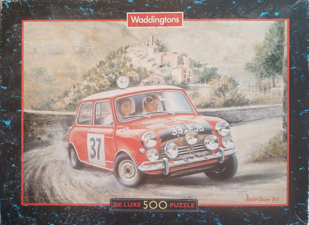 A vintage painting of a red Mini Cooper rally car driving on a dusty, winding mountain road.