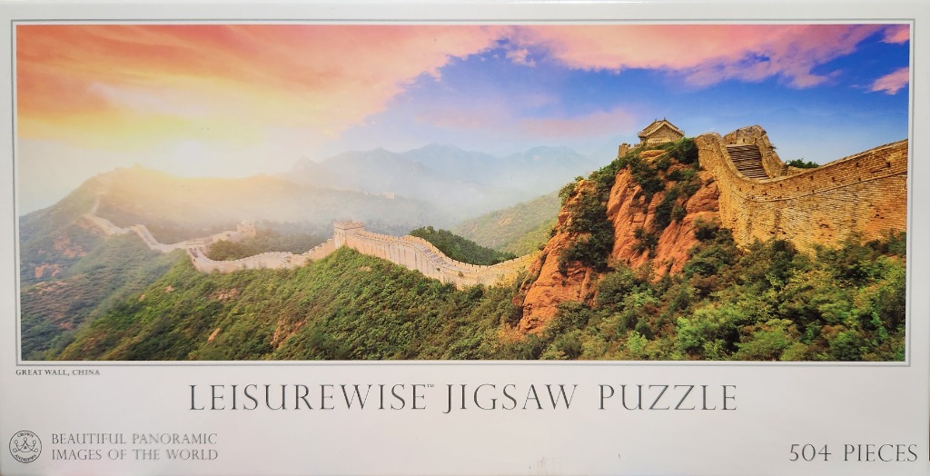 The Great Wall of China winds over verdant mountains at sunrise.