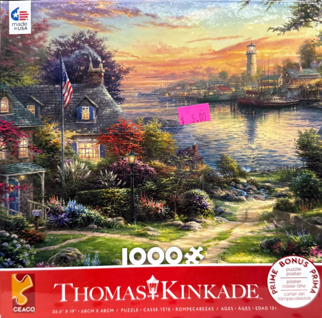 A peaceful coastal landscape at sunset with a stone cottage, a lighthouse, and a harbor reflecting golden light.