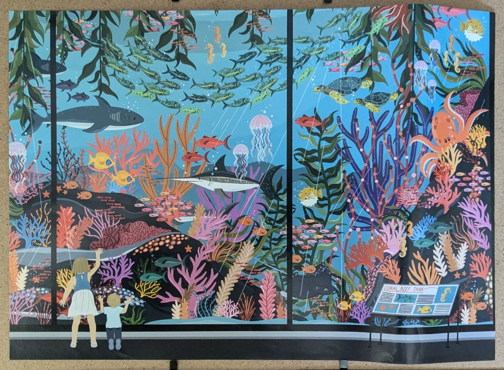 Children viewing a colorful aquarium reef scene with sharks, turtles, and tropical fish.