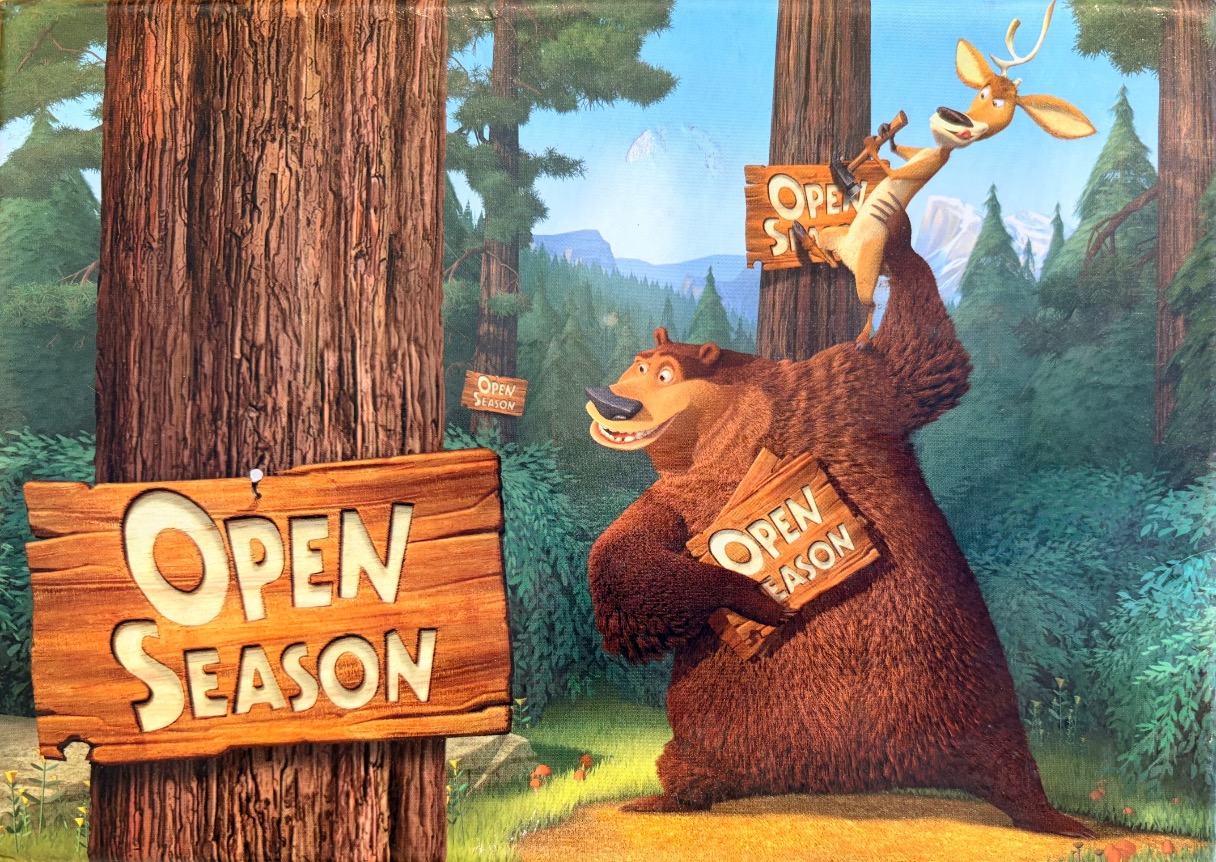 A cartoon grizzly bear holds a wooden sign while a deer clings to a tall tree in a forest setting.