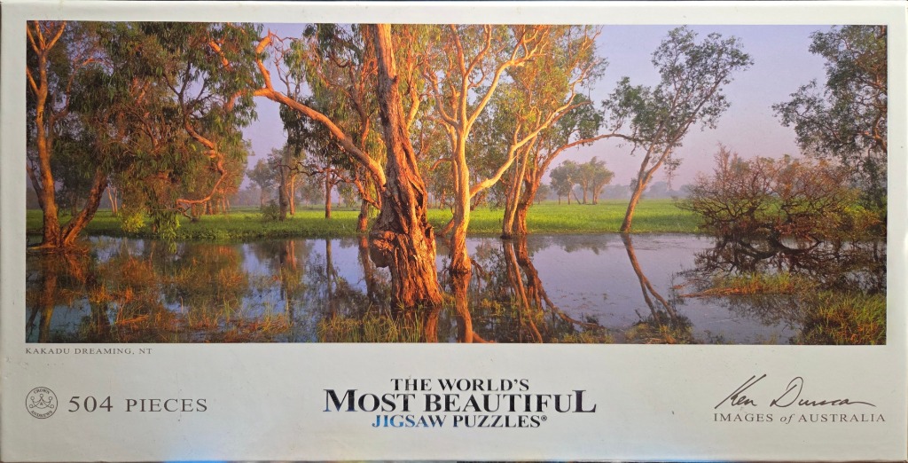A photograph of flooded wetlands in Kakadu at sunrise, featuring gum trees reflected in still water.