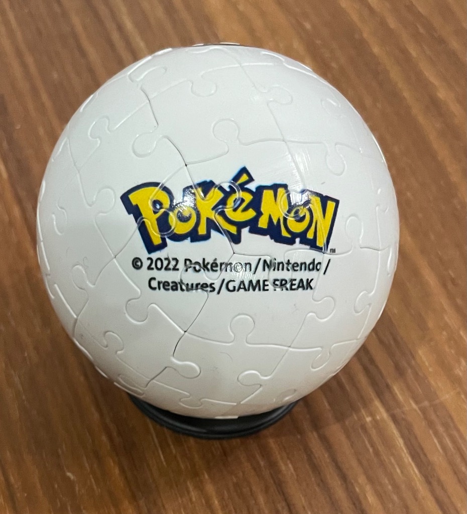 A spherical object featuring the official blue and yellow Pokemon logo centered on a white background.