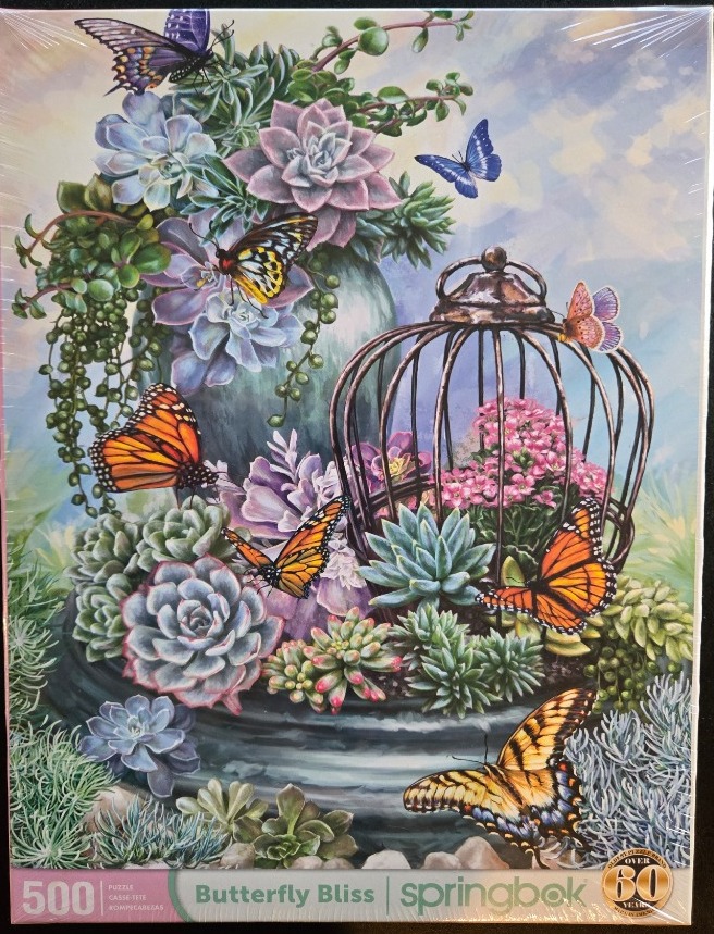 A collection of succulents and butterflies in and around a decorative metal birdcage and planter.