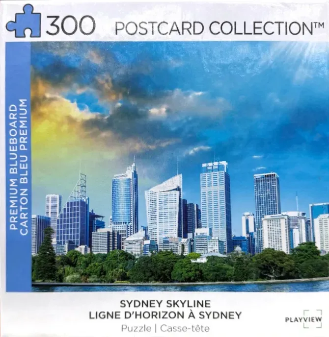 The Sydney skyline featuring modern skyscrapers above a lush green park against a brilliant blue and yellow sunset sky.