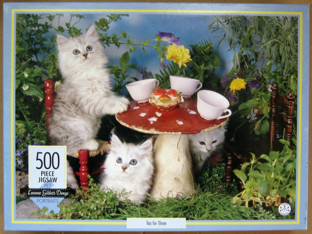 Three fluffy kittens gathered around a small mushroom-shaped table in a garden setting.