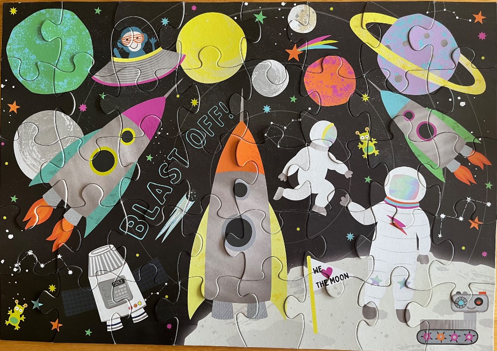Illustration of space with rockets, astronauts, and planets against a black background.