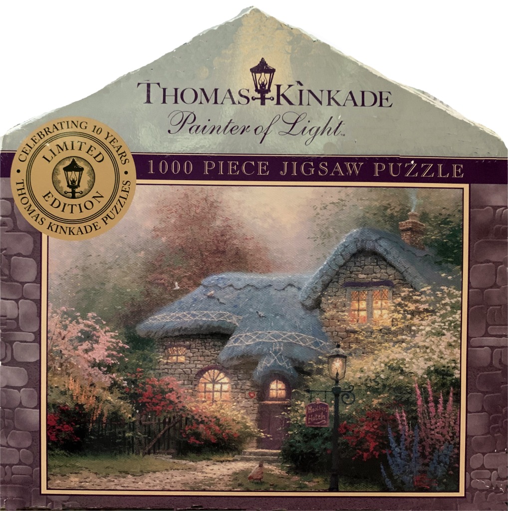 A cozy stone cottage with a thatched blue roof nestled in a lush, blooming garden at twilight.