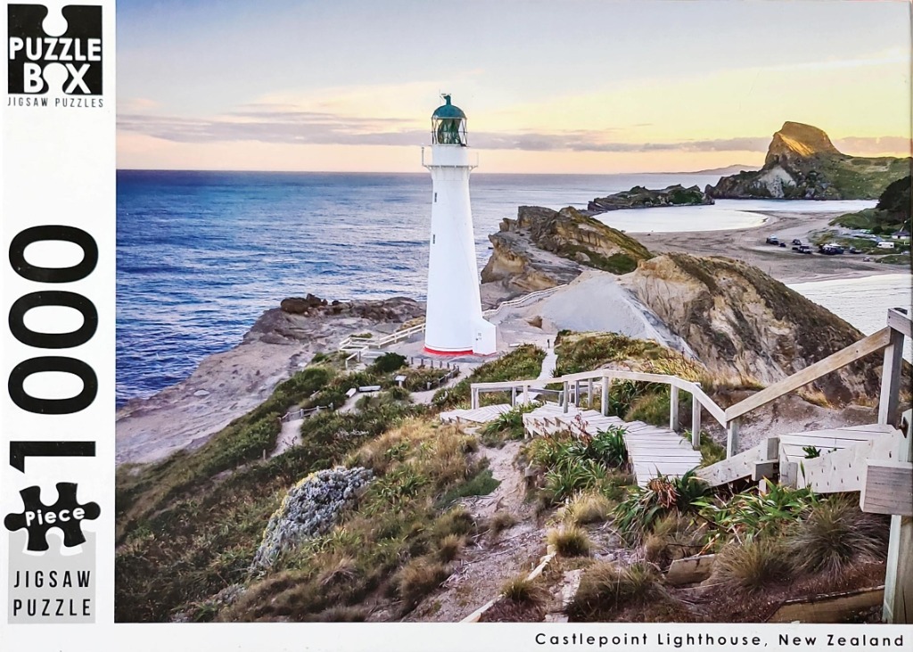 Castlepoint Lighthouse in New Zealand at sunset, view from a wooden staircase.