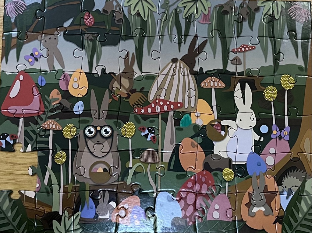 Whimsical illustration of rabbits and colorful eggs in a forest setting