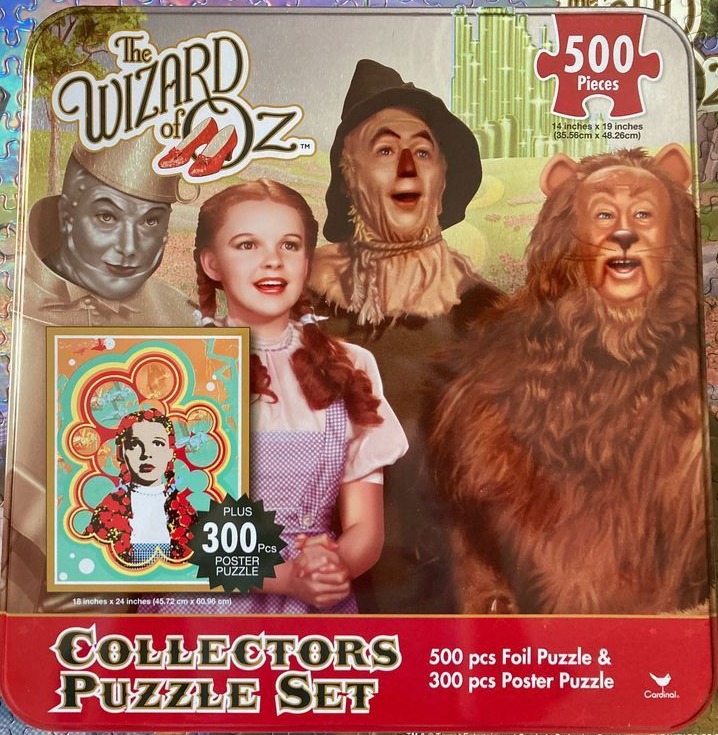 The Wizard of Oz characters Dorothy, Tin Man, Scarecrow, and Cowardly Lion stand before the Emerald City.