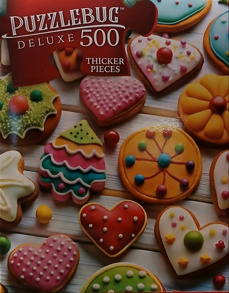 Assortment of colorful iced cookies on a light wooden surface