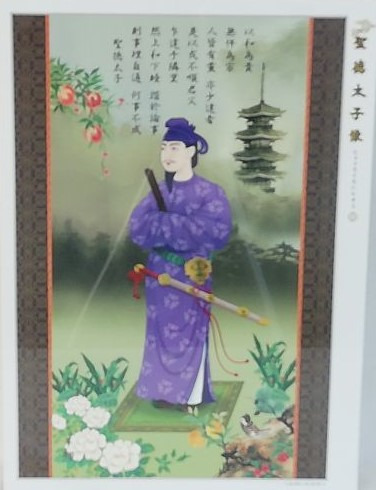 Traditional style painting of Prince Shotoku standing in a misty landscape with a pagoda and calligraphy.