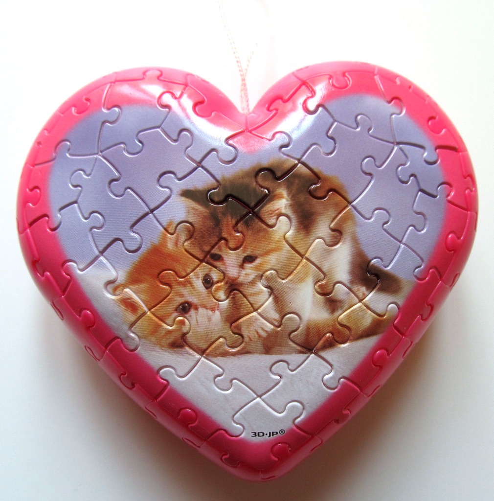 A heart-shaped object featuring an illustration of two fluffy kittens curled up together.
