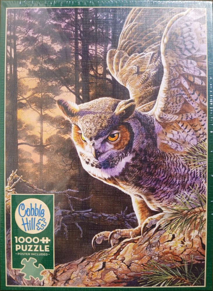 Great Horned Owl perched on a pine branch against a forest sunset