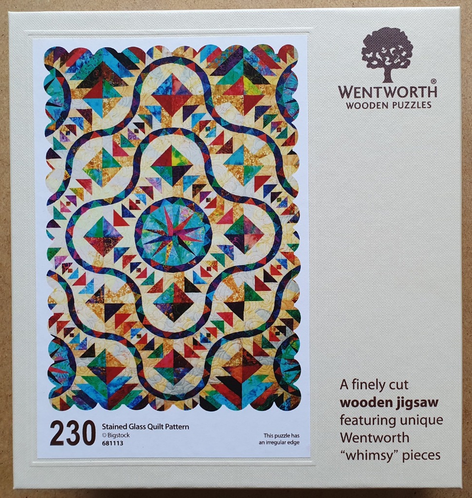 A vibrantly colored, scalloped-edge quilt block pattern featuring geometric shapes and stained-glass-style motifs.
