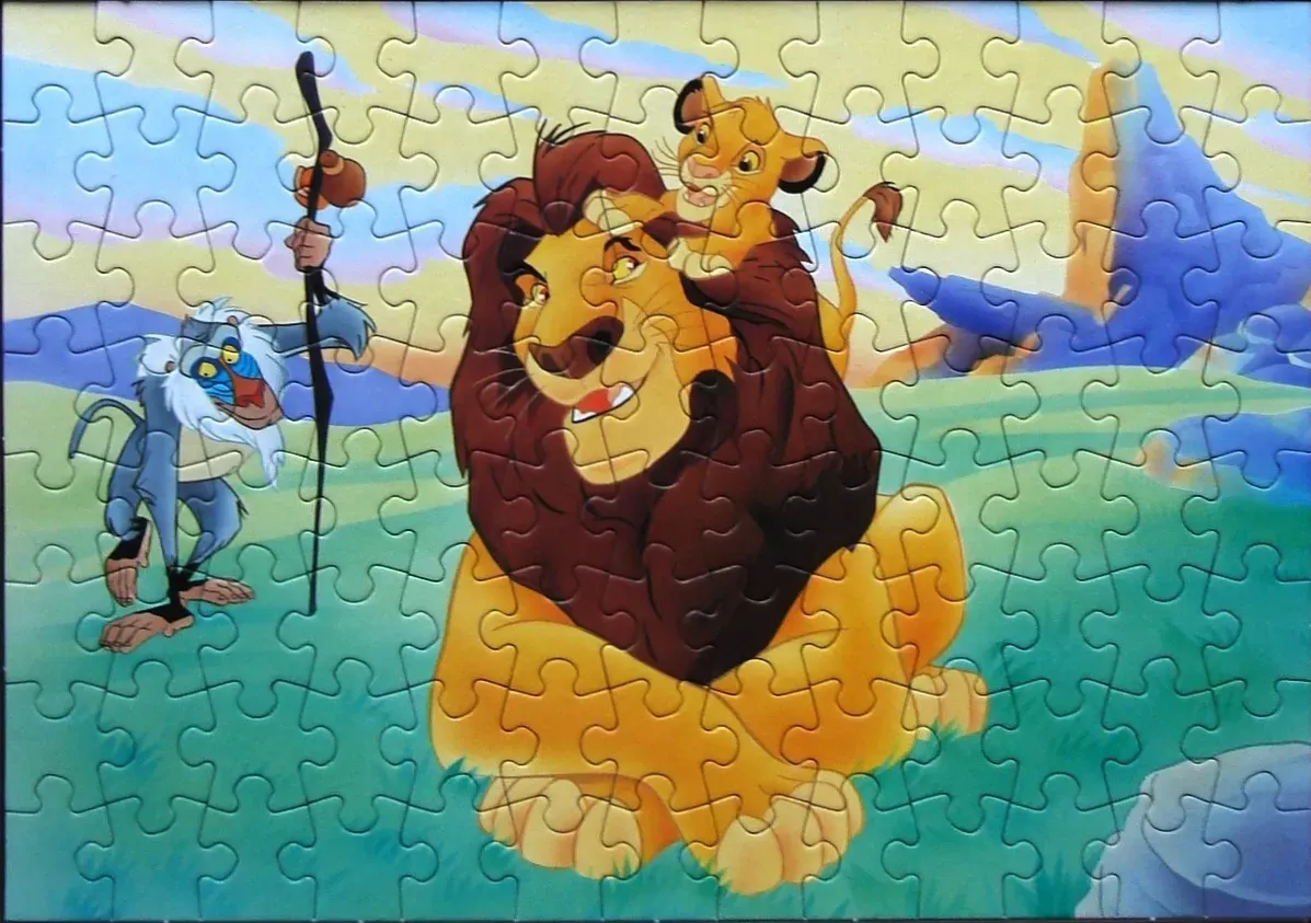 Cartoon illustration of Mufasa with Simba on his back and Rafiki standing beside them in a grassy savanna.