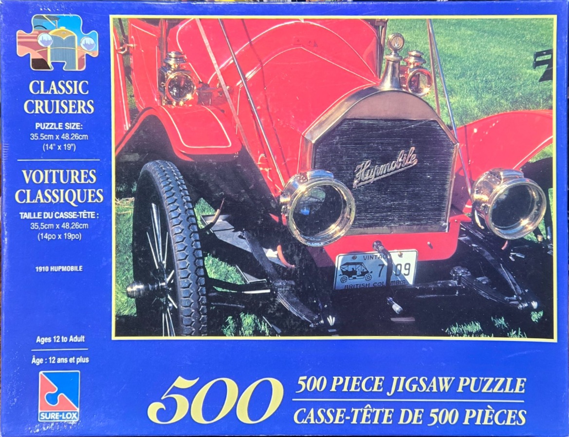 A close-up photograph of the front of a bright red 1910 Hupmobile vintage car.