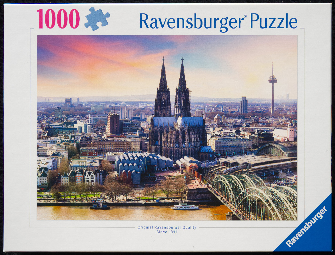 Panoramic view of Cologne Cathedral and the Rhine River at sunset.