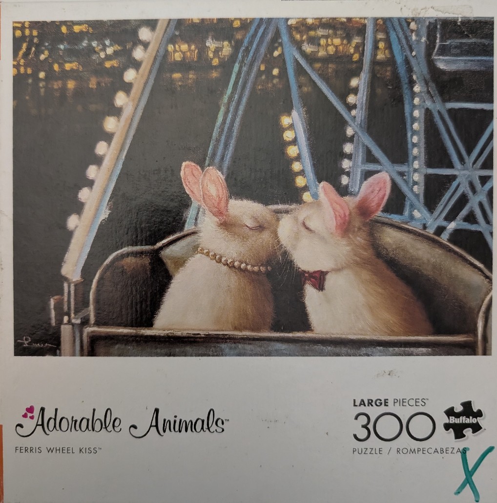 Two fluffy rabbits kissing while sitting in a ferris wheel car at night.