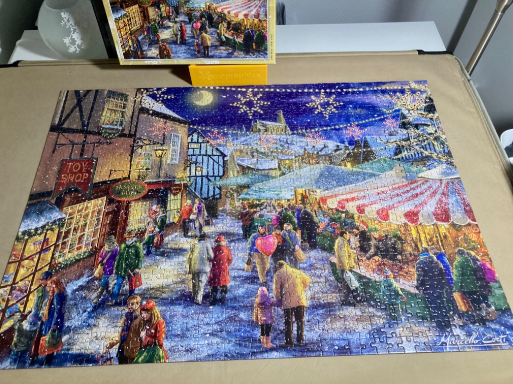 An illustrated Christmas market scene in an old European village at night.