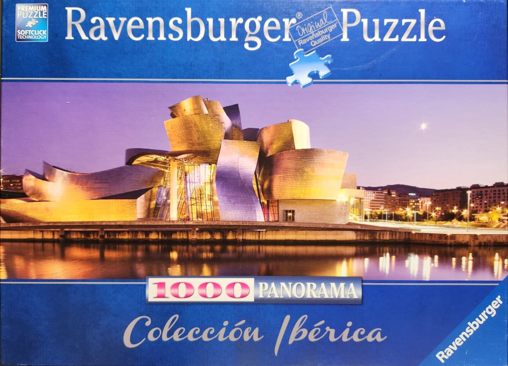 The Guggenheim Museum Bilbao at twilight with its titanium curves reflecting in the river.