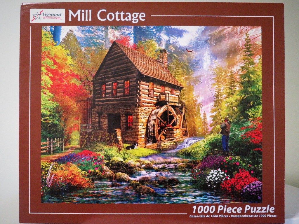 A rustic log cabin with a water wheel beside a stream, surrounded by colorful autumn foliage and a fisherman.