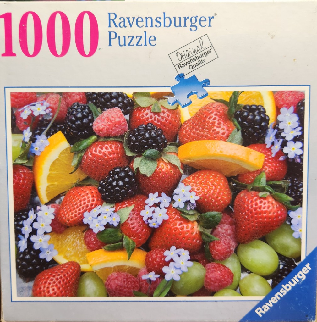 A vibrant assortment of fresh strawberries, blackberries, raspberries, orange slices, and small blue flowers.