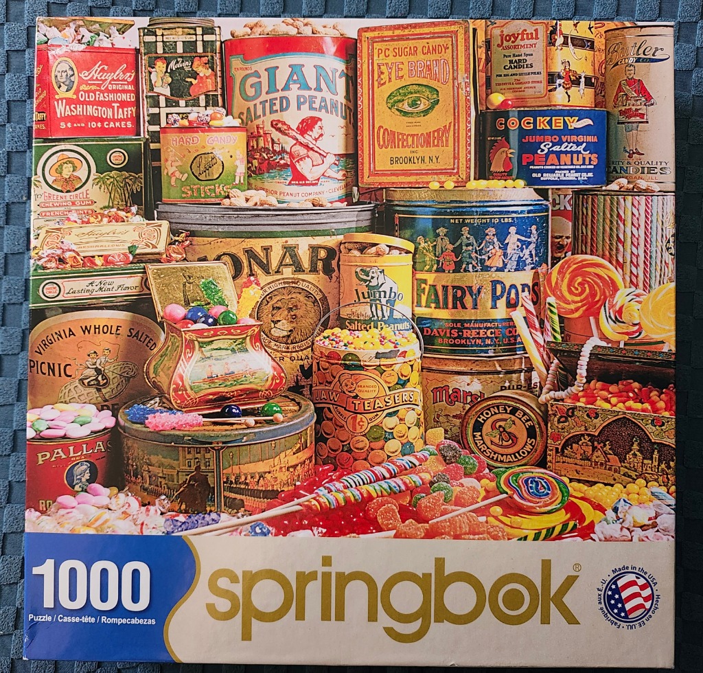A vintage-style collage of colorful candy and nut tins stacked together.