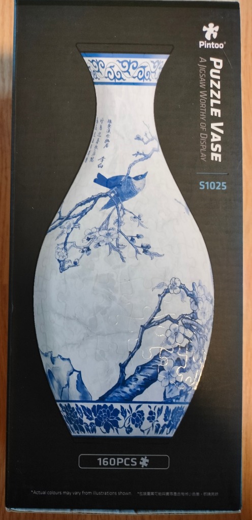 A blue and white porcelain-style vase featuring a bird on a cherry blossom branch.