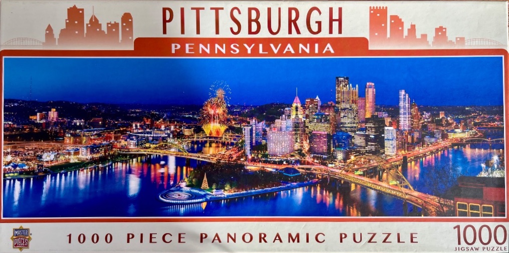 A panoramic night view of the Pittsburgh skyline featuring lit skyscrapers, glowing bridges, and fireworks over the river.