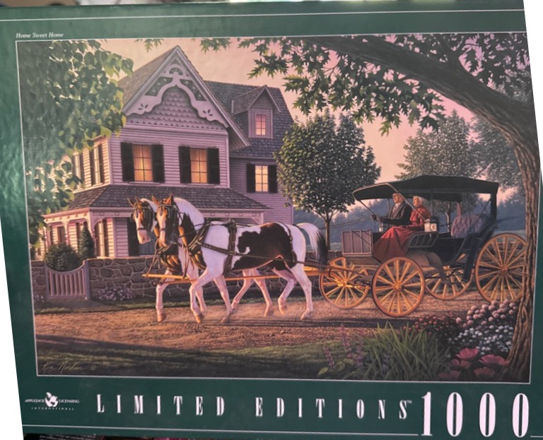 An elderly couple riding in a horse-drawn carriage past a charming Victorian house at sunset.