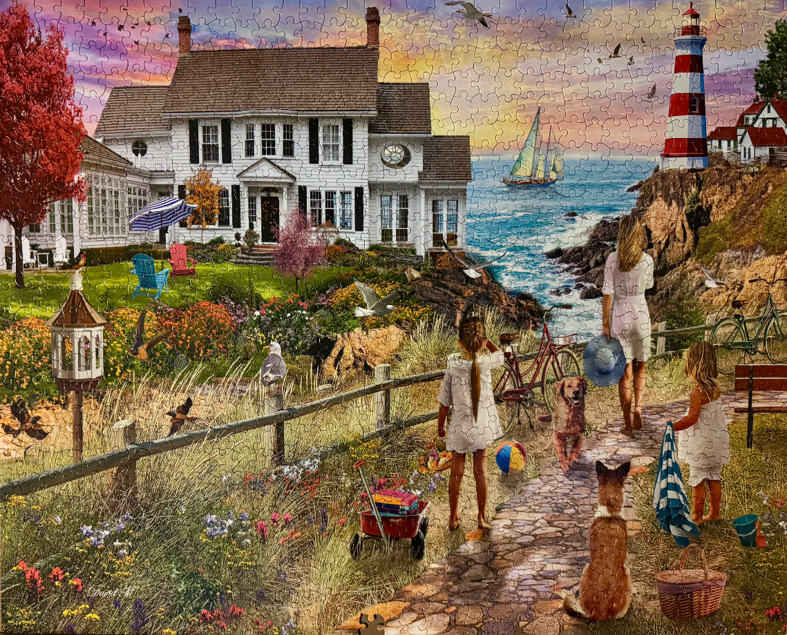 A coastal scene featuring a woman and two girls on a stone path near a large white house and a lighthouse at sunset.