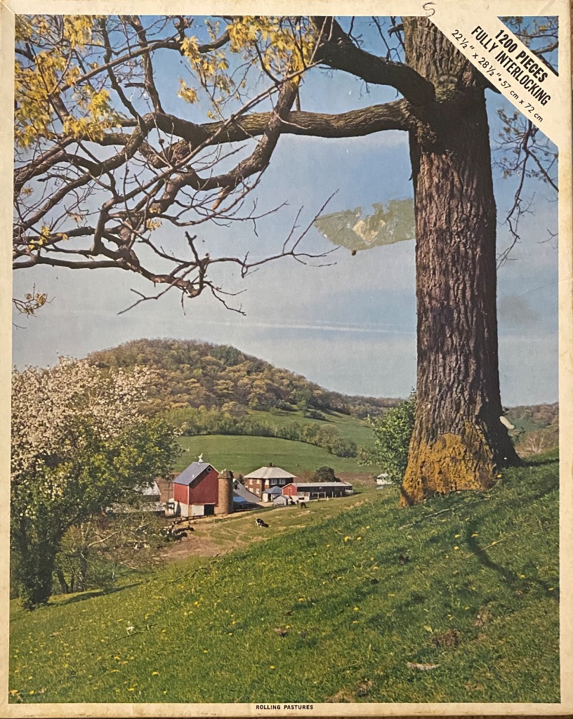 A countryside scene featuring a large tree in the foreground looking over a rolling valley with a farmhouse and barn.