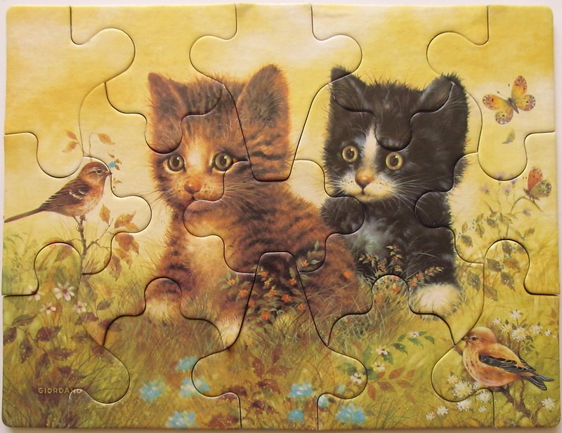 Two kittens sitting in a meadow with birds and butterflies in a warm, golden-hued illustration.