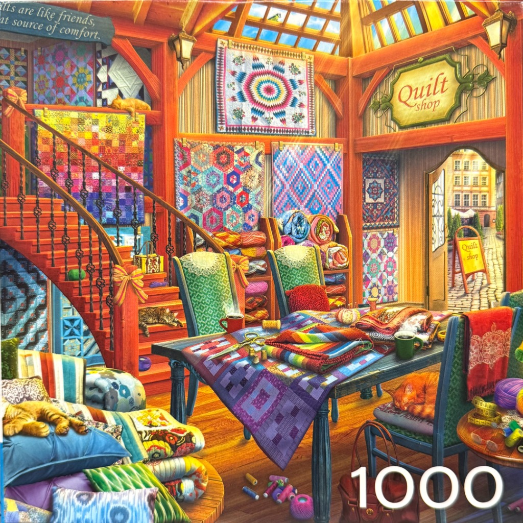 A cozy, vibrant interior of a quilt shop featuring colorful quilts, cats, a sewing table, and wooden architecture.