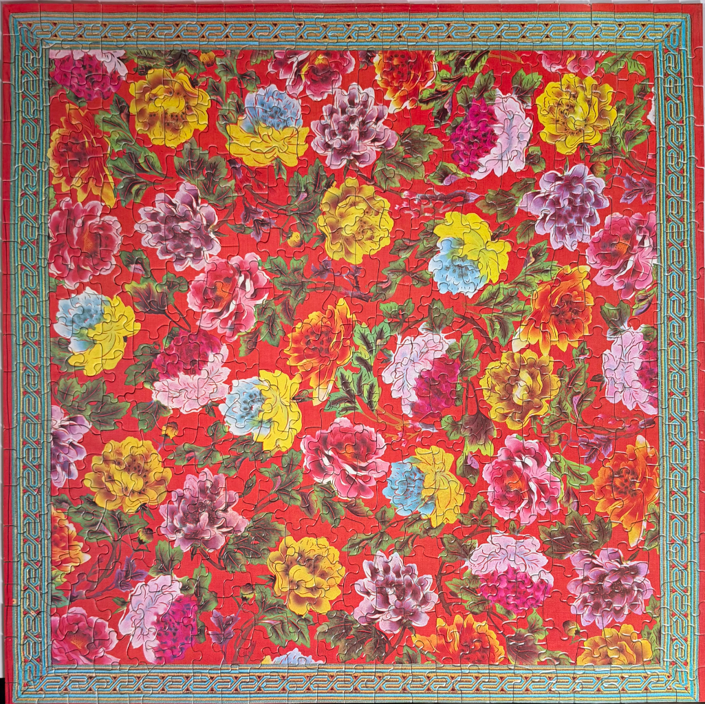 A floral pattern featuring vibrant, multicolored peonies on a bright red background with a turquoise border.