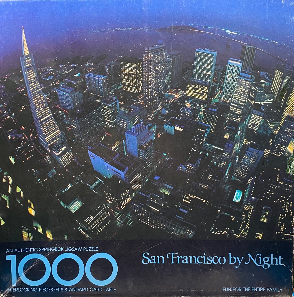 An aerial night photograph of the San Francisco skyline featuring the Transamerica Pyramid