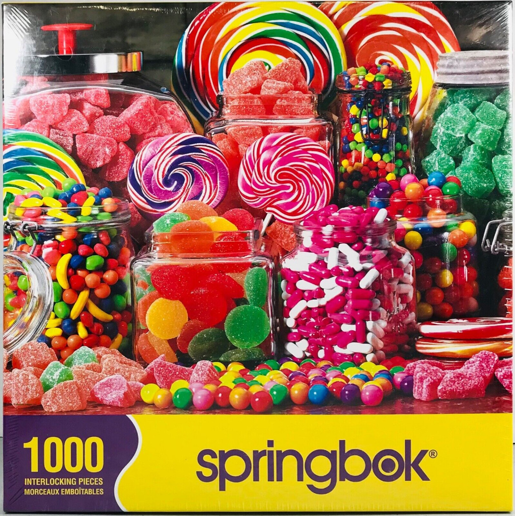 Assortment of colourful candies in glass jars and large swirl lollipops.