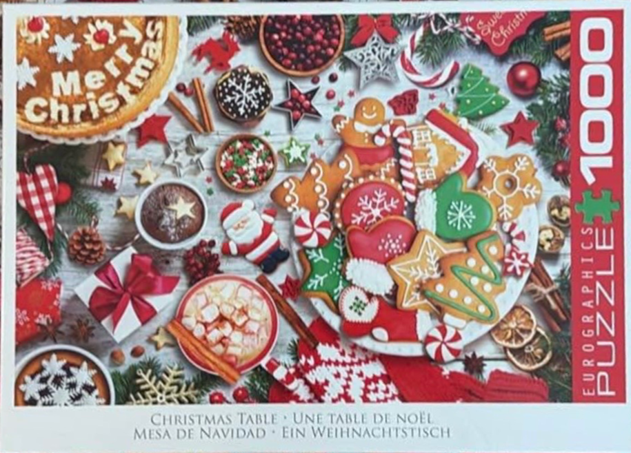 A flat-lay photograph of a rustic wooden table covered in Christmas-themed treats, cookies, and decorations.