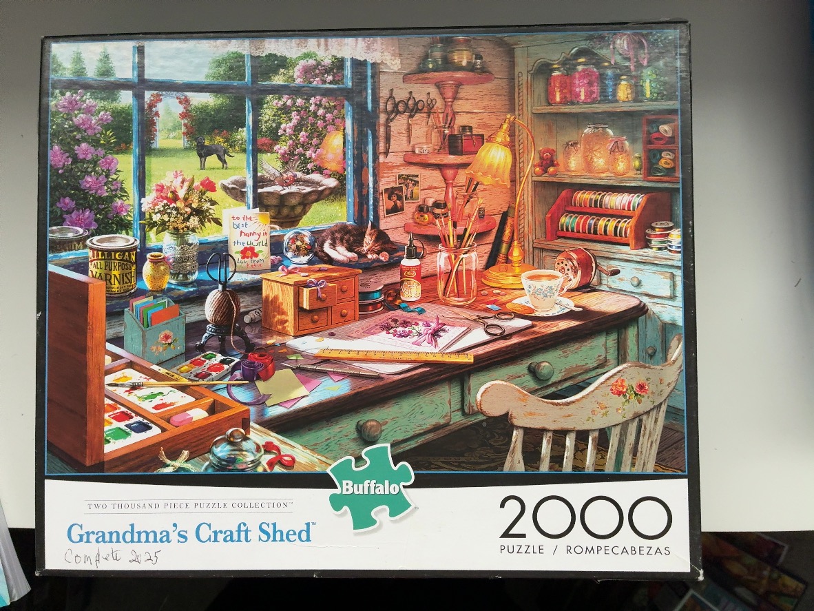 A cozy, rustic craft room filled with art supplies, a desk, and a view into a sunny garden through a window.