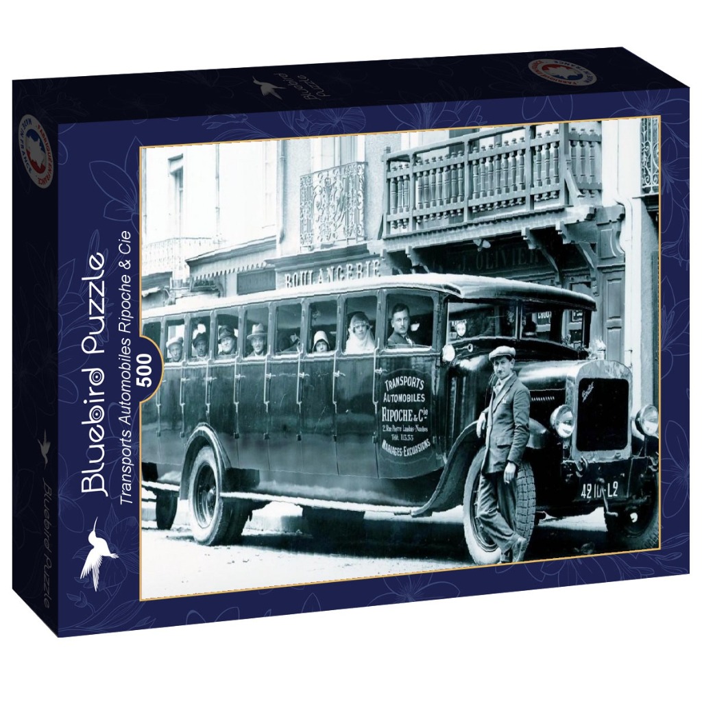 Vintage black and white photograph of a large bus with passengers parked in front of a French street shop.