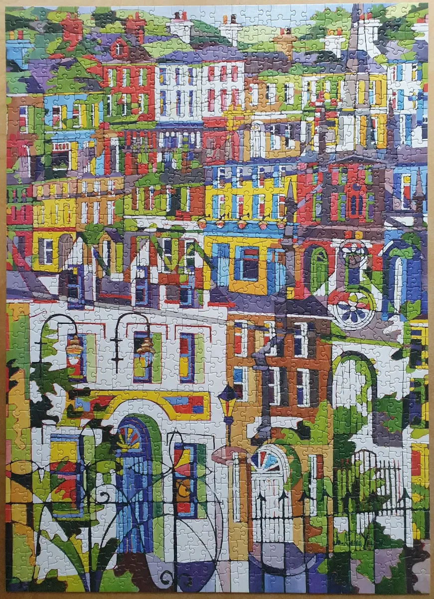 A colorful, stylized illustration of a dense urban street scene with stacked townhouses and ornate wrought-iron railings.