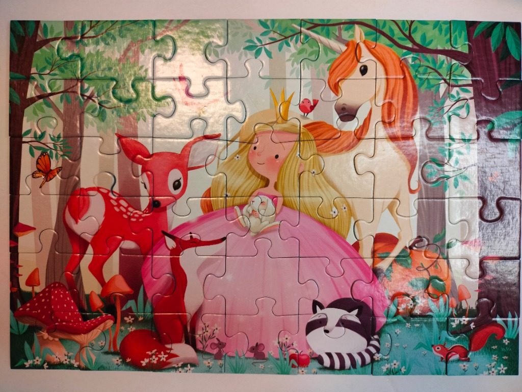 A whimsical illustration of a blonde princess with a unicorn and woodland animals in a forest.