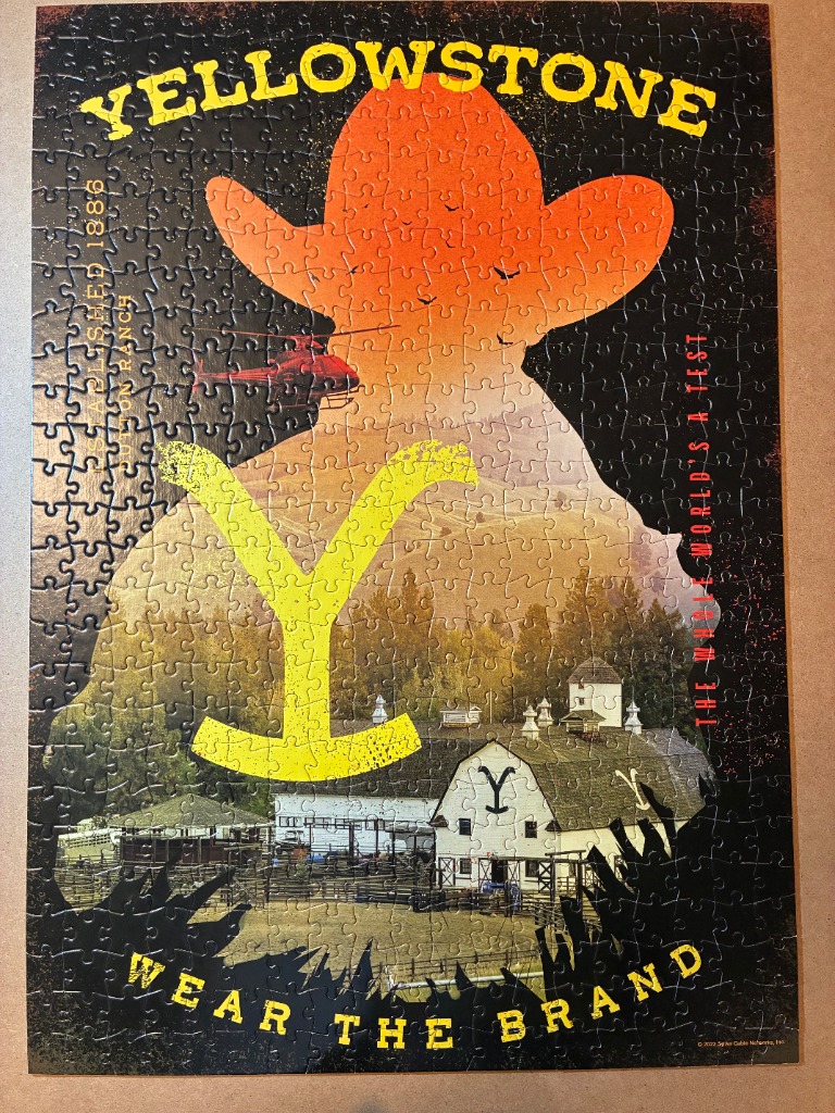 Graphic poster of the Yellowstone ranch featuring a cowboy hat silhouette, a helicopter, and a rustic barn.