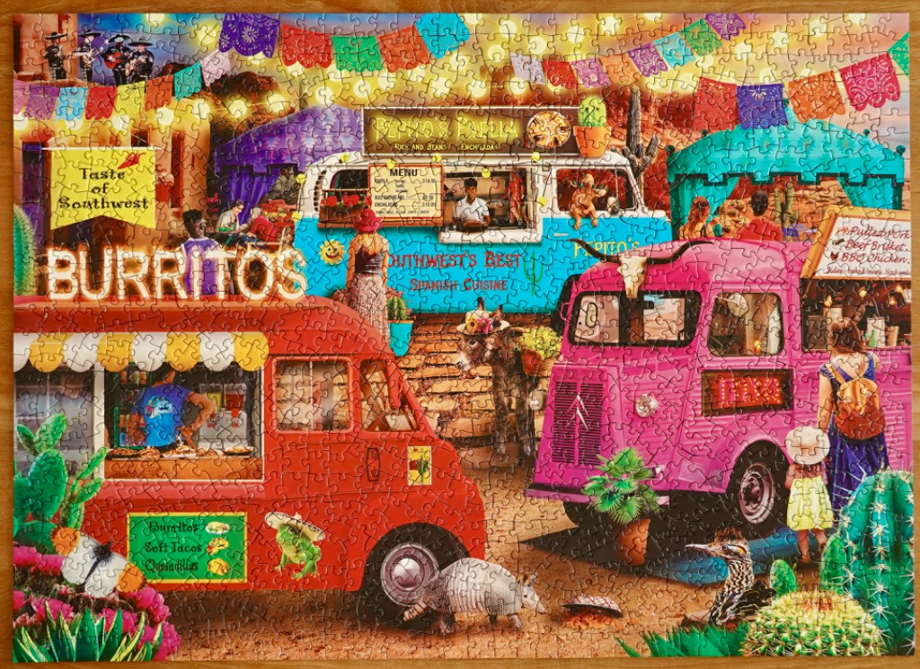 Colorful illustration of a vibrant food truck festival in the desert featuring bright red, blue, and pink trucks.