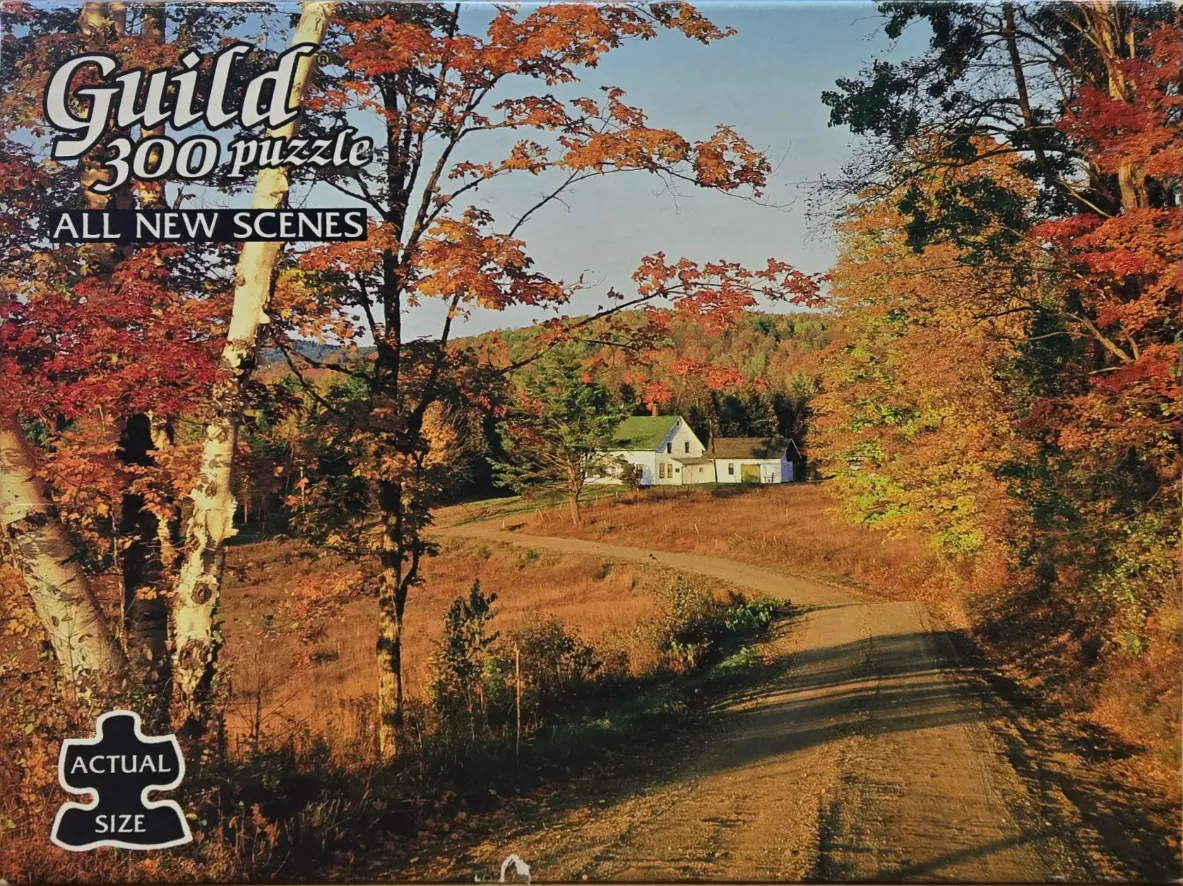 A rural autumn landscape featuring a dirt road leading to a white farmhouse surrounded by vibrant fall trees.