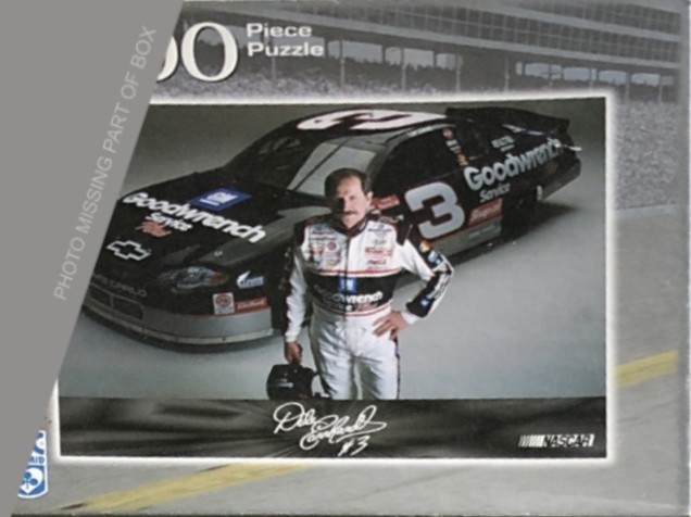 A photograph of Dale Earnhardt standing in front of his black number 3 race car.