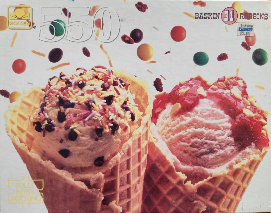 Two ice cream cones in waffle cups topped with sprinkles, chocolate chips, and strawberry sauce against a white background.