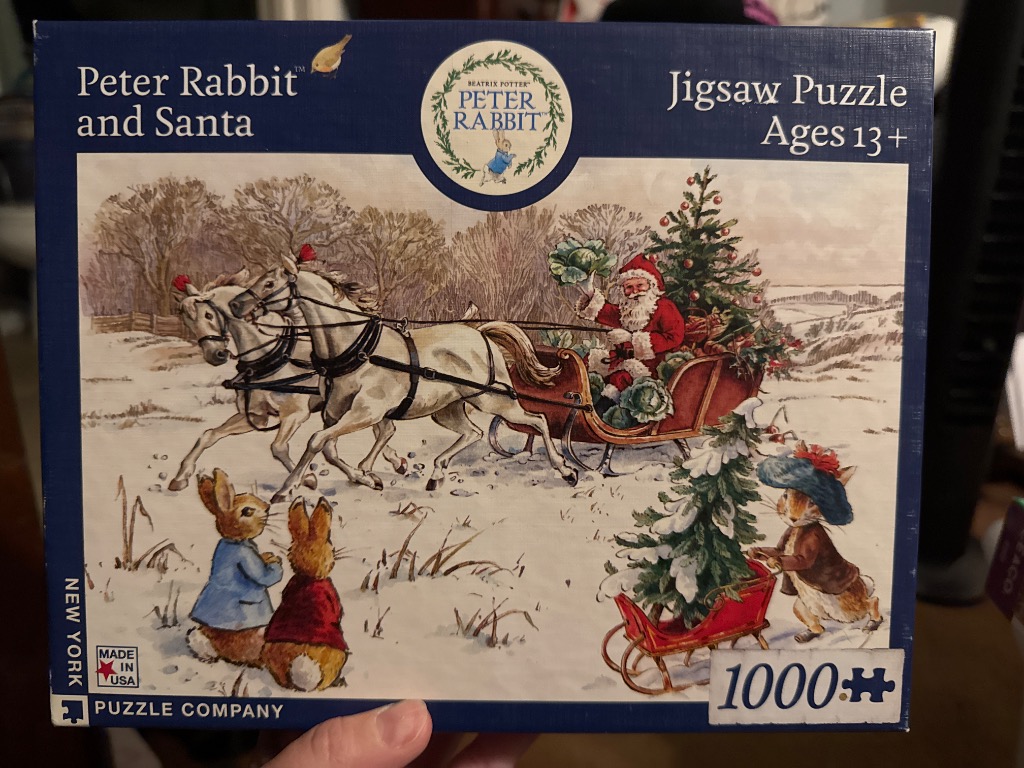 Classic illustration of Peter Rabbit watching a horse-drawn sleigh with Santa Claus in a snowy winter field.
